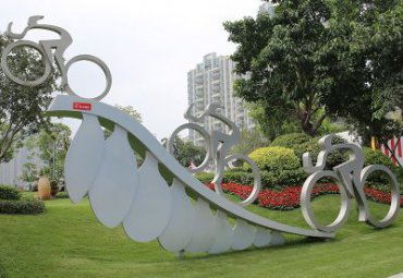 贵州某公园不锈钢抽象树叶自行车人物雕塑案例